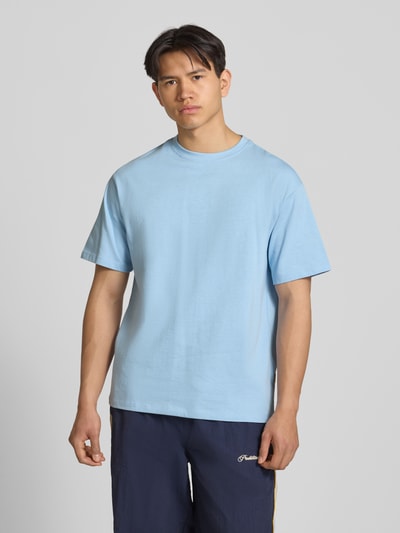 Männermodel trägt Oversized T-Shirt Modell 'FISHER' von Blend in Hellblau aus reiner Baumwolle mit Rundhalsausschnitt, Ganzkörperansicht von vorne.