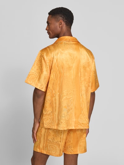 Męskimodel nosi koszulę casualową Relaxed Fit Freizeithemd mit Reverskragen Modell 'Resort' von COLUCCI z elastycznej mieszanki materiałów, krótki rękaw, brustasza, listwa guzikowa, naszywka z logo, długość tyłu w rozmiarze M: 70 cm, szerokość w rozmiarze M: 56 cm, długość rękawów w rozmiarze M: 26 cm, całość w odcieniach żółci, wzór żakardowy, tekstura z połyskiem, Ganzkörperansicht Rückansicht