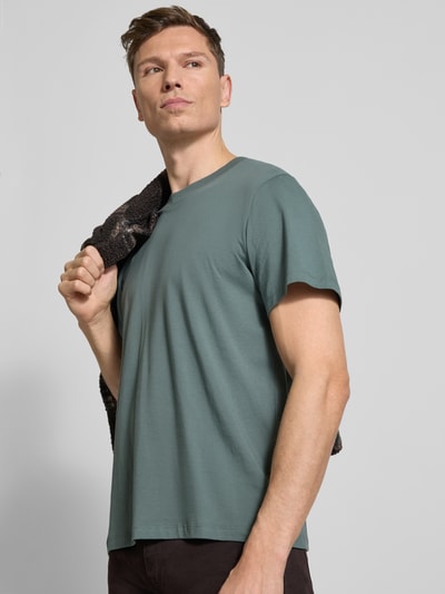 Męski model trägt Regular Fit T-Shirt aus reiner Baumwolle Modell 'ASPAN' von Selected Homme, efekt: jednolity kolor, dżersej, okrągły dekolt, krótki rękaw, Ganzkörperansicht von vorne.