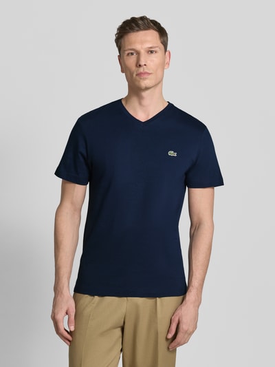 Męski model nosi Regular Fit T-Shirt aus reiner Baumwolle von Lacoste, efekt: jednolity kolor, wyhaftowane logo, dekolt w serek, krótki rękaw, bawełna; całkowity widok z przodu.
