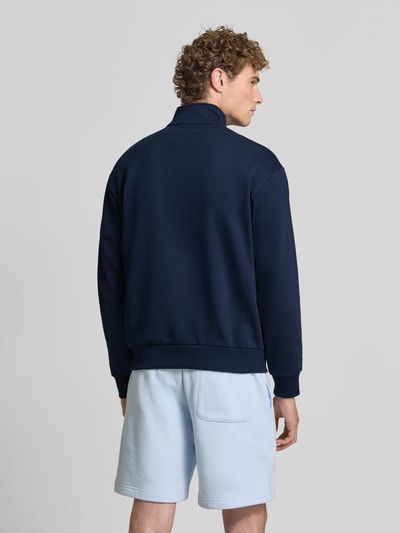 Männermodel trägt Regular Fit Troyer aus Baumwoll-Mix von Lacoste in Dunkelblau, glatte Oberfläche, Ganzkörperansicht Rückansicht. Herren Troyer von Lacoste