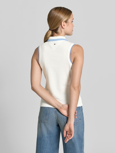 Frauenmodel trägt Slim Fit Poloshirt aus Baumwoll-Mix von Tommy Hilfiger, Two-Tone-Optik, Logo-Stitching, Kontrast-Nähte, Ganzkörperansicht Rückansicht.