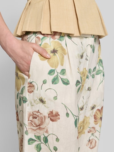 Frauenmodel trägt Leinenhose mit französischen Eingrifftaschen von Jake*s Collection, florales Muster in Beige, Grün und Gelb, reine Leinen, Nahaufnahme Oberkörper.
