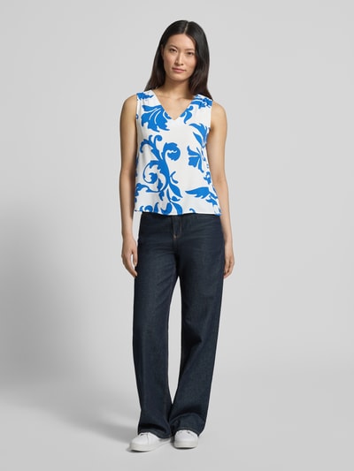 Modelka kobieca ma na sobie top Loose Fit Top aus reiner Viskose Modell 'EASY JOY' od Vero Moda, efekt: wzór na całej powierzchni, krój loose fit, dekolt w serek, bez rękawów, materiał: wiskoza; widok całej sylwetki z przodu.