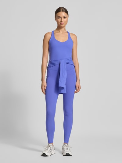Frauenmodel trägt Slim Fit Top mit integriertem Bustier Modell 'Anywhere' von Fabletics in Blau, elastischer Material-Mix, Ganzkörperansicht von vorne.