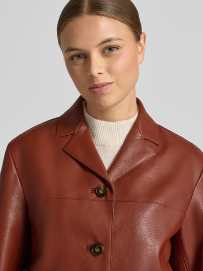 Frauenmodel trägt Jacke in Leder-Optik Modell 'SABI' von Mango, Regular-Fit, Reverskragen, Knopfleiste, Eingrifftaschen, Nahaufnahme Oberkörper.