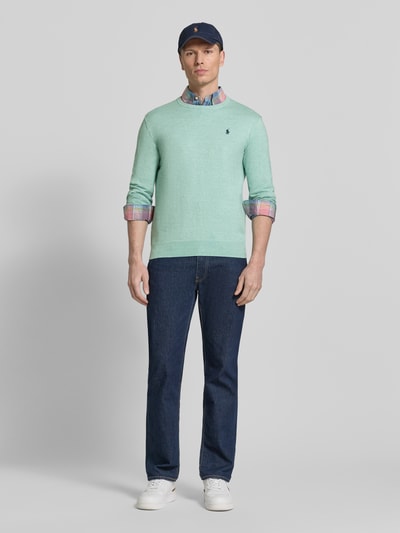 Męski model nosi Slim Fit Pullover aus reiner Baumwolle od Polo Ralph Lauren, kolor jednolity, krój slim fit, logo, dekolt okrągły, długie rękawy, bawełniany sweter, widok całej sylwetki z przodu.