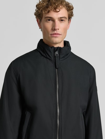 Männermodel trägt schwarze Regular Fit Steppjacke mit Stehkragen Modell 'LIGHT' von Strellson, Herren Steppjacke, Nahaufnahme Oberkörper.