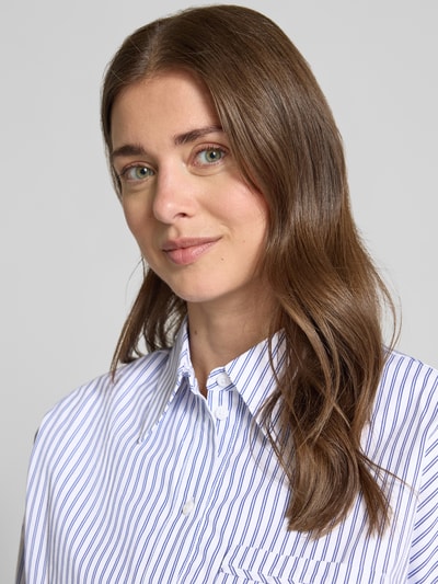 Vrouwenmodel draagt Bluse mit überschnittenen Schultern van Rich & Royal in blauw-witte strepen, puur katoen, regular fit, overhemdkraag, knoopsluiting, borstzak, Nahaufnahme bovenlichaam.