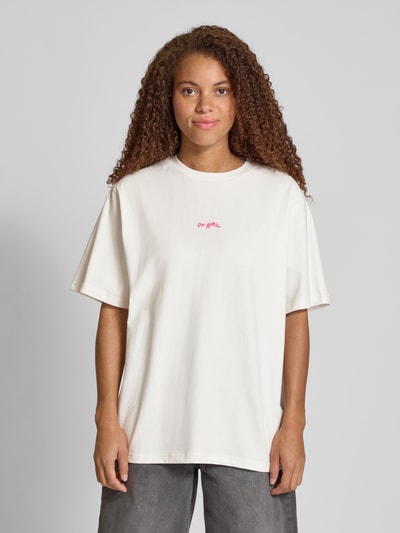 Frauenmodel trägt Oversized T-Shirt mit Label-Print von OH APRIL aus reiner Baumwolle, gerippter Rundhalsausschnitt, Ganzkörperansicht von vorne.