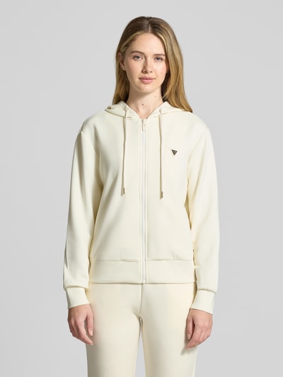 Vrouwenmodel draagt Regular Fit Sweatshirt met Logo-Applikatie model 'Olympe' van Guess Activewear, crèmekleurig, met capuchon, ritssluiting, elastische boorden, elastische materiaalmix met modal, vooraanzicht bovenlichaam.