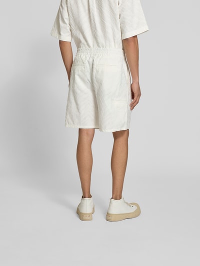 Mężczyznamodel nosi Shorts mit Strukturmuster von Kenzo z bawełny, krój straight fit, wzór strukturalny, kieszenie z tyłu, widok całej sylwetki z tyłu.