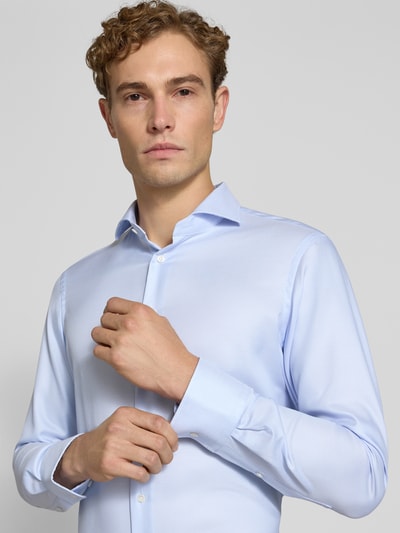 Männermodel trägt Slim Fit Business-Hemd aus reiner Baumwolle von Christian Berg Men in Hellblau mit Haikragen, Nahaufnahme Oberkörper. Context: Herren Business-Hemd, Langarm, Knopfleiste, Sportmanschetten, schmale Passform.
