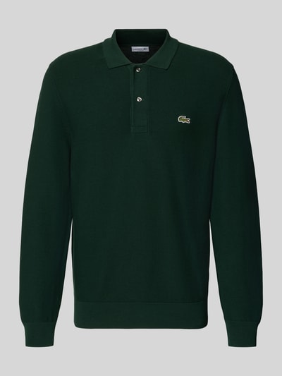 Produktfoto, Regular Fit Poloshirt aus reiner Baumwolle von Lacoste in dunklem Grün mit glatter Textur und Markenlogo auf der Brust.