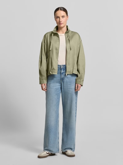 Frauenmodel trägt Jacke aus Lyocell-Baumwoll-Mix Modell 'Jarusa' von OPUS in hellem Grün, Reißverschluss, Stehkragen, Relaxed Fit, Ganzkörperansicht von vorne.