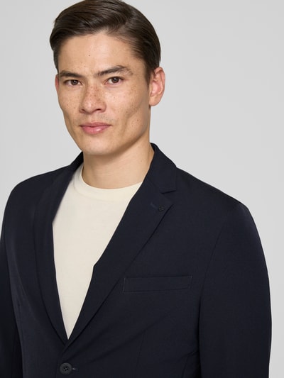 Männermodel trägt Slim Fit 2-Knopf-Blazer mit Reverskragen von MARKUP aus Material-Mix in Dunkelblau, Nahaufnahme Oberkörper.