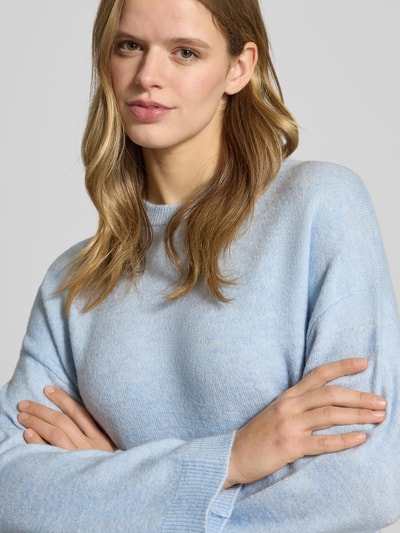 Frauenmodel trägt Relaxed Fit Strickpullover mit Crew Neck Modell 'SIMONI' von Only in melierter Optik, Nahaufnahme Oberkörper.