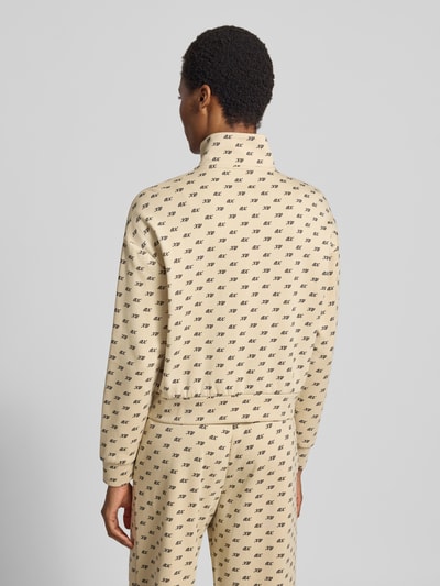 Frauenmodel trägt Sweatjacke mit Reißverschluss von Armani Exchange, beigefarbener Baumwoll-Mix mit Allover-Label-Print, Rückansicht.
