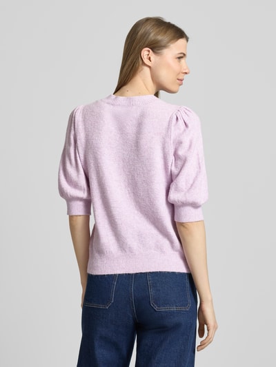 Vrouwenmodel draagt Regular Fit Gebreide pullover met crew neck model 'DOFFY' van Vero Moda in effen kleur, gebreide look, applicatie met labelstitching, ronde hals, 1/2-mouwen, geribde mouw- en rompzoom, materiaalverwerking: knitwear. Ganzkörperansicht Rückansicht.