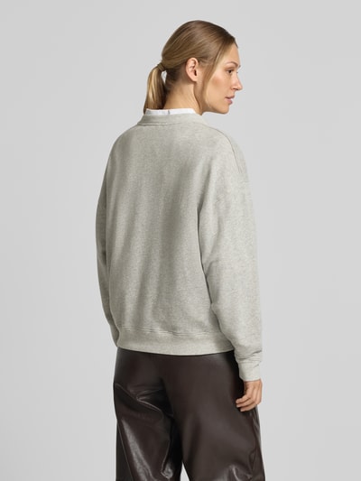 Modelka nosi luźny sweatshirt z mieszanki bawełny i elastanu ba&sh, okrągły dekolt, nadruk z logo, model 'BENJAMIN', widok od tyłu