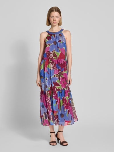 Kobiece model prezentuje Relaxed Fit Midikleid mit floralem Allover-Print od Christian Berg Woman Selection, sukienka midi z kwiatowym nadrukiem na całej powierzchni, krój relaxed fit, marszczenia, nieprzezroczysta halka pod spódnicę, bez rękawów, długość tyłu w rozmiarze 36: 127 cm, szerokość w rozmiarze 36: 50 cm, widok całej sylwetki z przodu.