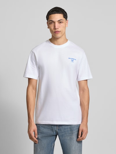 Męski model nosi Relaxed Fit T-Shirt aus reiner Bio-Baumwolle Modell 'FRED' von Only & Sons, biały, jednolity, krótkie rękawy, okrągły dekolt, czysty bawełna organiczna, nadruk z przodu, widok całej sylwetki z przodu.