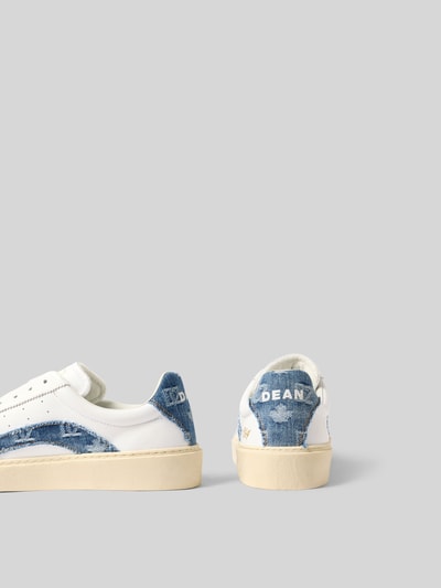 Produktfoto, Sneaker mit Kontrastbesatz aus Denim von Dsquared2, abgerundete Form, Schnürverschluss, strukturierte Sohle, Label-Details, Kontrastbesatz aus Denim, Absatzhöhe 4 cm, Schafthöhe 7 cm, weiße und blaue Farben auf rauer Textur, Rückansicht