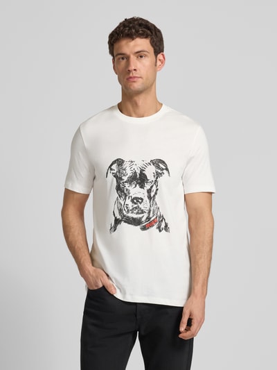 Männermodel trägt Regular Fit T-Shirt aus reiner Baumwolle Modell 'DUBROX' von HUGO, weiß, Rundhals, Motiv-Print, Ganzkörperansicht von vorne.