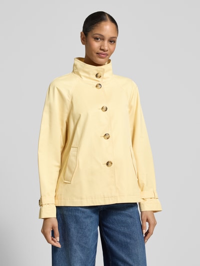 Vrouwenmodel draagt Jacke mit Stehkragen und Ärmelriegeln van Fuchs Schmitt in lichtgeel, katoenmix, regular fit, steekzakken, knoopsluiting, opstaande kraag, ruglengte maat 36: 67 cm, schouderbreedte: 42 cm, borstwijdte: 52 cm, mouwlengte: 44 cm. Vooraanzicht bovenlichaam.