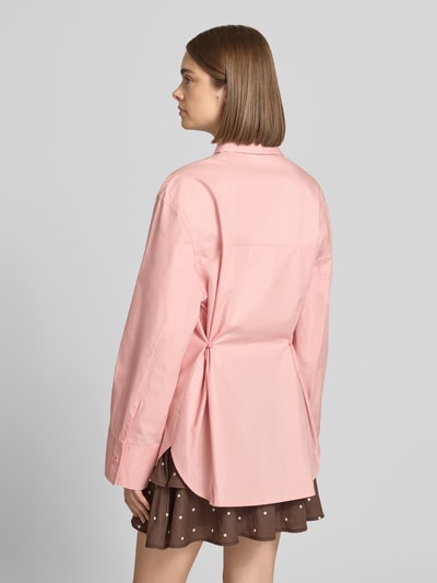 Frauenmodel trägt Oversized Hemdbluse mit Brusttasche Modell 'Demi' von Topshop in Rosa, reine Baumwolle, Rückansicht, Ganzkörperansicht.