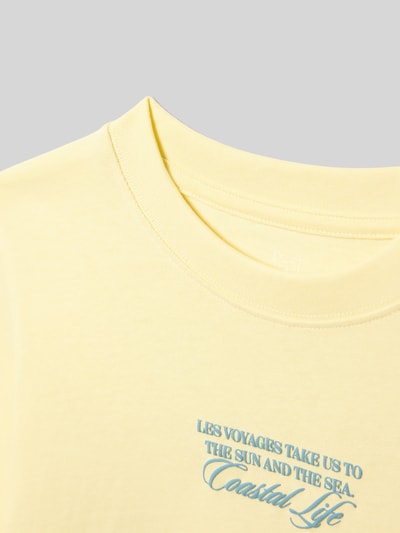 Productfoto, T-shirt met ronde hals model 'CASSIS' van Jack & Jones voor kinderen van puur katoen, regular fit, statementprint, ruglengte maat 140: 51 cm, zachtgeel met blauwe tekst, gladde textuur