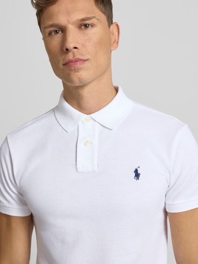 Männermodel trägt Poloshirt mit Label-Stitching von Polo Ralph Lauren in Weiß, Reine Baumwolle, Slim Fit, Nahaufnahme Oberkörper.