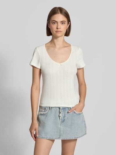 Modelka nosi biały damski t-shirt z krótkim rękawem, model 'SWEETIE' od Levi's®, prążkowana struktura, jasnoniebieska jeansowa spódnica, widok całej sylwetki z przodu