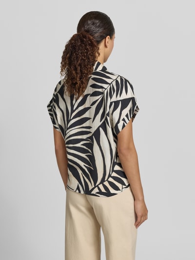 Frauenmodel trägt Bluse aus Viskose-Mix mit Hemdblusenkragen Modell 'LIFE' von Mango, Straight Fit, schwarzes Blattmuster, Ganzkörperansicht Rückansicht, Knopfleiste, Ärmel mit fixiertem Aufschlag, Rückenlänge bei Größe S: 53 cm, Ärmellänge bei Größe S: 15 cm.