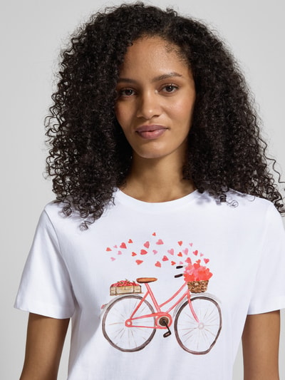 Vrouwenmodel draagt T-shirt met motiefprint en ronde hals van Jake*s Casual, puur katoen, regular fit, ruglengte maat S 57 cm, close-up bovenlichaam.