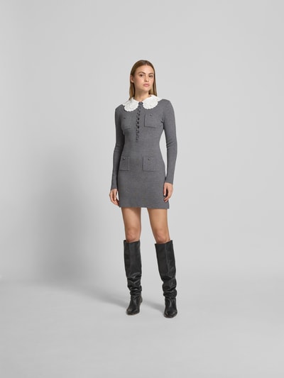 Frauenmodel trägt Minikleid mit Woll-Anteil von Self-Portrait in Grau mit weißen Details, tailliert, Strick-Optik, Ganzkörperansicht von vorne.