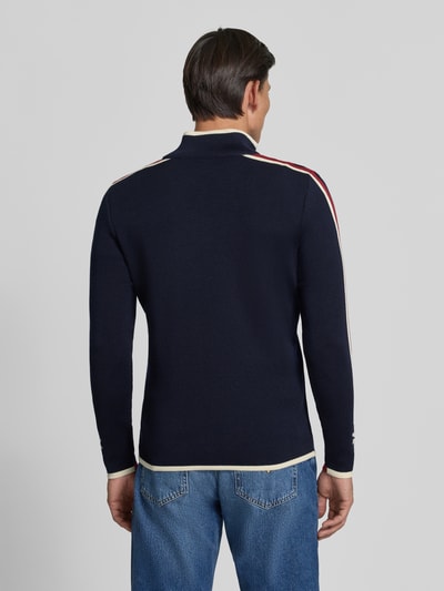 Männermodel trägt Wollpullover mit Label-Print Modell 'Nale' von Dale of Norway, reine Wolle, gerader Schnitt, Ganzkörperansicht Rückansicht.