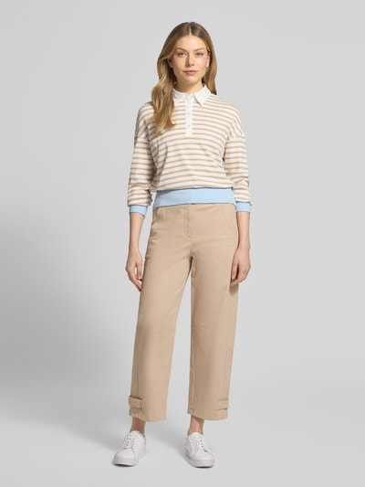 Frauenmodel trägt Regular Fit Poloshirt mit breitem Bund von Marc Cain, gestreift in Beige und Weiß, elastischer Baumwoll-Mix, Ganzkörperansicht von vorne.
