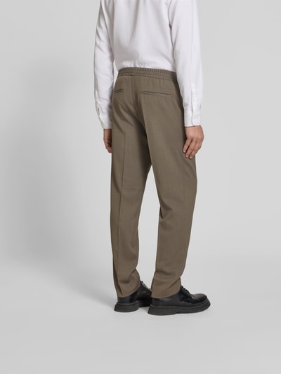 Männermodel trägt Straight Fit Stoffhose mit Woll-Anteil von Filippa K in Braun, elastischer Bund, Bundfalten, Rückansicht Ganzkörperansicht.