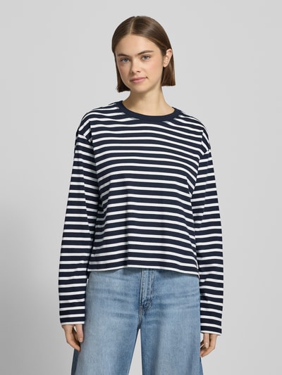 Kobiece modelka nosi Loose Fit Langarmshirt aus reiner Baumwolle von Marc O'Polo Denim, efekt: w paski, okrągły dekolt, widok z przodu, bluzka z długim rękawem, aplikacja z wyhaftowanym logo, materiał: czysta bawełna, Ganzkörperansicht von vorne.