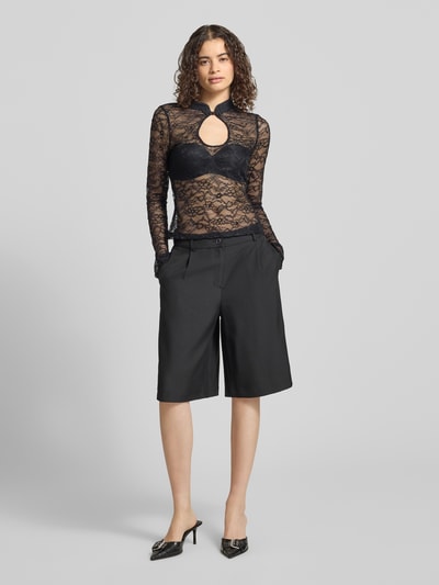 Frauenmodel trägt Slim Fit Longsleeve mit floraler Allover-Spitze von Gina Tricot aus Elastischer-Material-Mix, Schlüsselloch-Ausschnitt, Langärmelig, Stehkragen, Semitransparent, Rückenlänge bei Größe S: 56 cm, schwarze Farbe, Ganzkörperansicht von vorne.