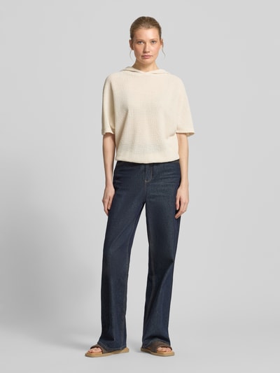 Frauenmodel trägt Strickshirt mit Kapuze Modell 'Gikaria' von OPUS, cremefarben im Strukturmuster, Relaxed Fit, Ganzkörperansicht von vorne.