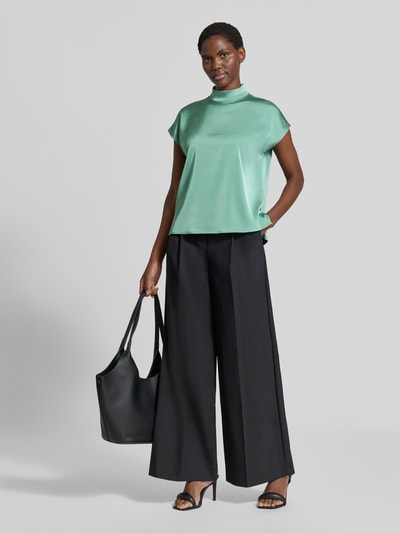 Frauenmodel trägt Regular Fit Blusentop aus reiner Baumwolle von Jake*s Collection in Mintgrün, kombiniert mit schwarzer Hose, Ganzkörperansicht von vorne.