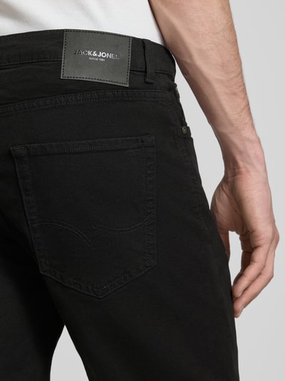 Männermodel trägt schwarze Jeansshorts mit Umschlag und Eingrifftaschen Modell 'RICK ALLEN' von Jack & Jones, Detailaufnahme Rückansicht, Baumwoll-Elasthan-Mix, Regular Fit, dezente Struktur.