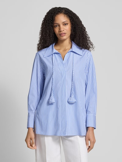 Modelka kobieca nosi Slim Fit Bluse mit Bindegürtel Modell 'STABARIN' od Marella, niebieskie paski, czysta bawełna, krój slim fit, kołnierzyk koszulowy, pasek, długość tyłu 73 cm, długość rękawa 58 cm, widok całej sylwetki z przodu.