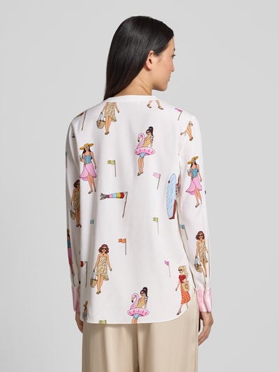 Modelka nosi Relaxed Fit Tunika-Bluse mit Allover-Motiv-Print von HERZENS w jasnych kolorach, wzór z motywem na całej powierzchni, długie rękawy, dekolt z lamówką, długość tyłu 70 cm w rozmiarze 36, długość rękawów 63 cm w rozmiarze 36, tekstura gładka, widok całej sylwetki z tyłu.