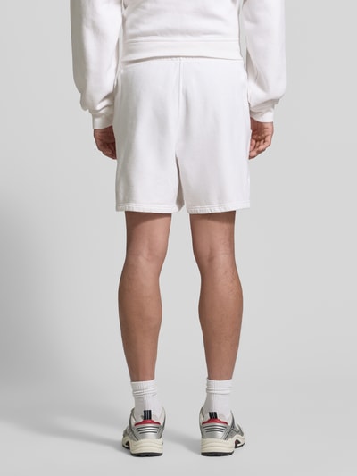 Männermodel trägt Shorts mit Logo Modell 'PLIZZY' von American Vintage aus Reine Baumwolle im Relaxed-Fit, weiß, Ganzkörperansicht Rückansicht.