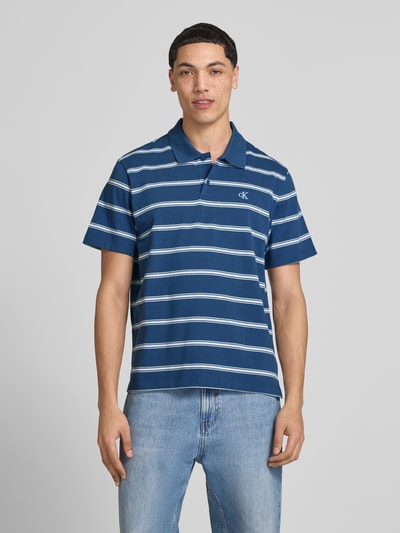 Männermodel trägt Regular Fit Poloshirt mit Logo-Stitching von Calvin Klein Jeans, Reine Baumwolle, Polokragen, kurze Knopfleiste, Ganzkörperansicht von vorne.
