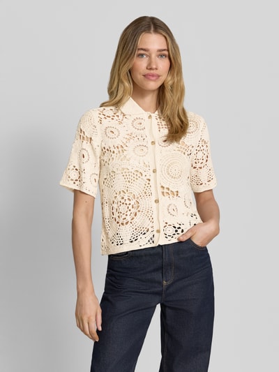 Modelka nosi Bluse in Häkel-Optik mit Knopfleiste od Milano Italy, bluzka z bawełny, prosty krój, imitacja wykonania na szydełku, wykładany kołnierz, listwa guzikowa, półprzezroczysty efekt, długość tyłu w rozmiarze S: 54 cm, długość rękawów w rozmiarze S: 26 cm, przód, zbliżenie na górną część ciała.