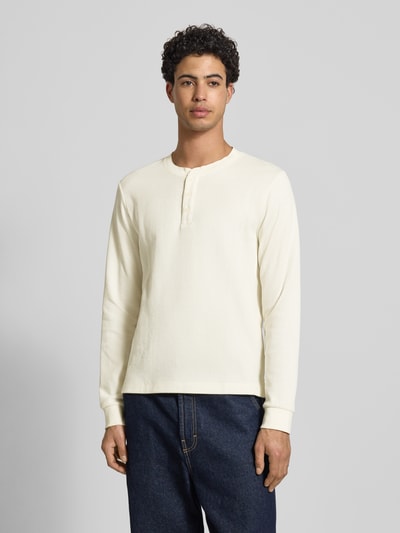 Männermodel trägt Regular Fit Longsleeve in Strick-Optik Modell 'Niagara' von JACK & JONES, Baumwoll-Mix, Henley-Ausschnitt, Ganzkörperansicht von vorne.
